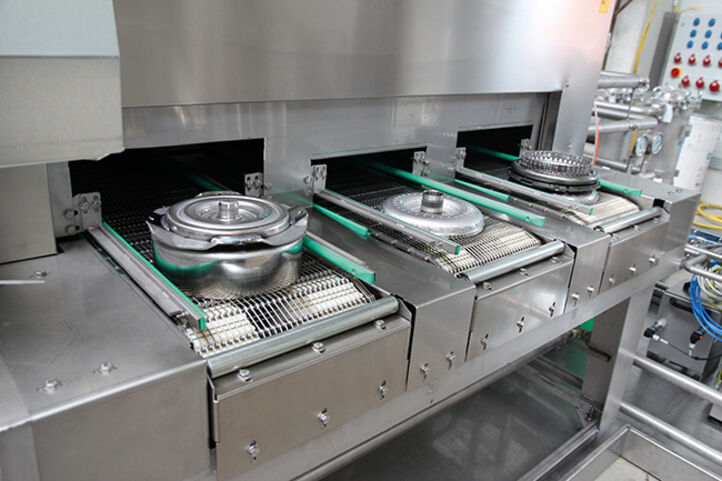 Unterschiedliche Wandlerkomponenten fahren auf getrennten Förderbändern in BvL-Reinigungsanlage ein.