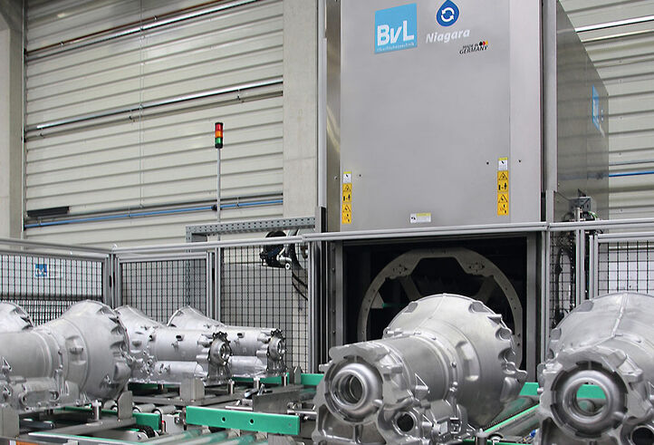 All-round cleaning of gearbox housings with optimum integration of the cleaning system into the production process: seamless communication between an external gantry crane for loading and a robot for unloading.